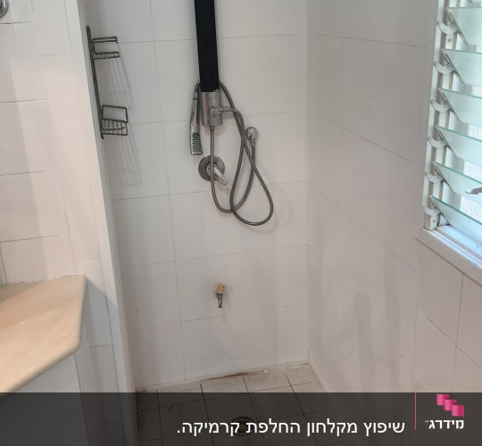 מקלחת עם אריחים לבנים, צינור ומקלחת יד